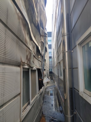 인접 건물 사이 손상된 판넬 외벽